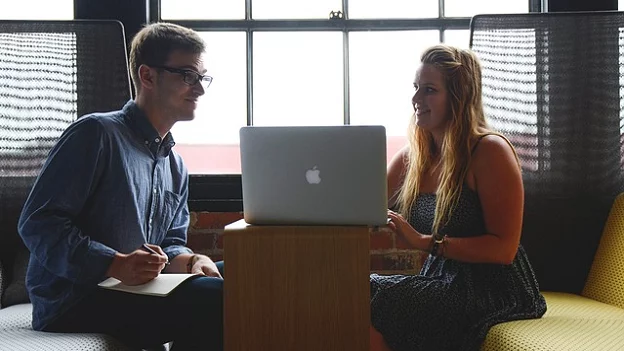 2 people discussing over a laptop