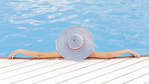 Woman wearing a hat relaxing in a pool