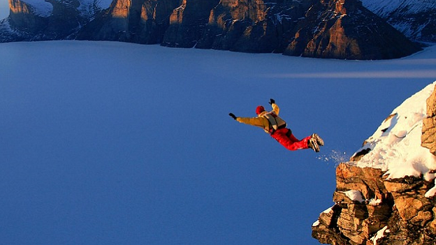 Person jumping off a mountain