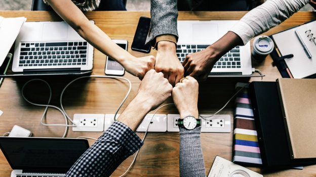 Hands in the middle over a desk