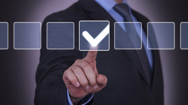 Homem a tocar em botão virtual de confirmação | Melhores formas de gerenciar os processos de autorização de ausências