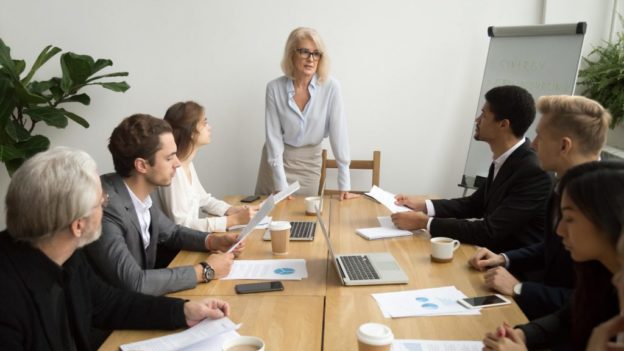 Mulher a liderar reunião corporativa | O que são gerentes conectores e por que precisas deles?