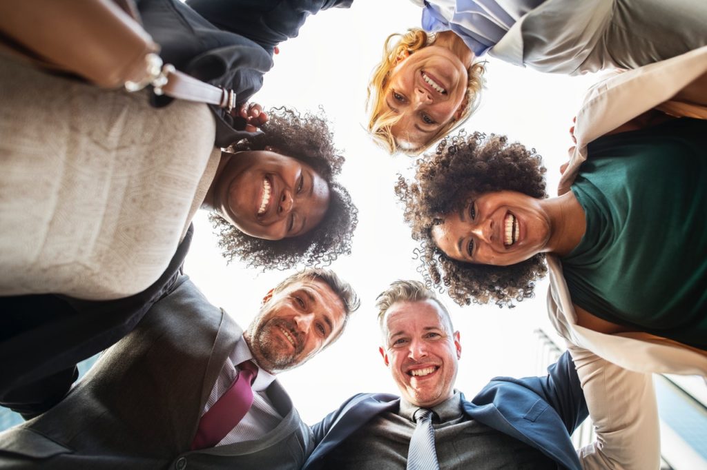 Colaboradores reunidos a sorrir felizes em equipa | Como a tua empresa deve lidar com os trabalhadores da economia gig?