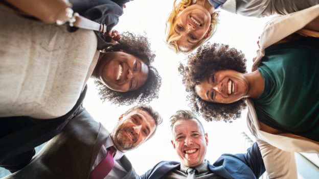 Colaboradores reunidos a sorrir felizes em equipa | Como a tua empresa deve lidar com os trabalhadores da economia gig?
